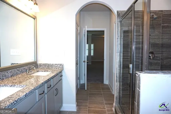 a bathroom with a granite countertop sink and a shower