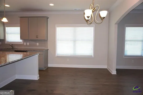 a kitchen with stainless steel appliances granite countertop a sink a window and wooden floors