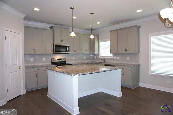 a kitchen with granite countertop a sink cabinets and stainless steel appliances