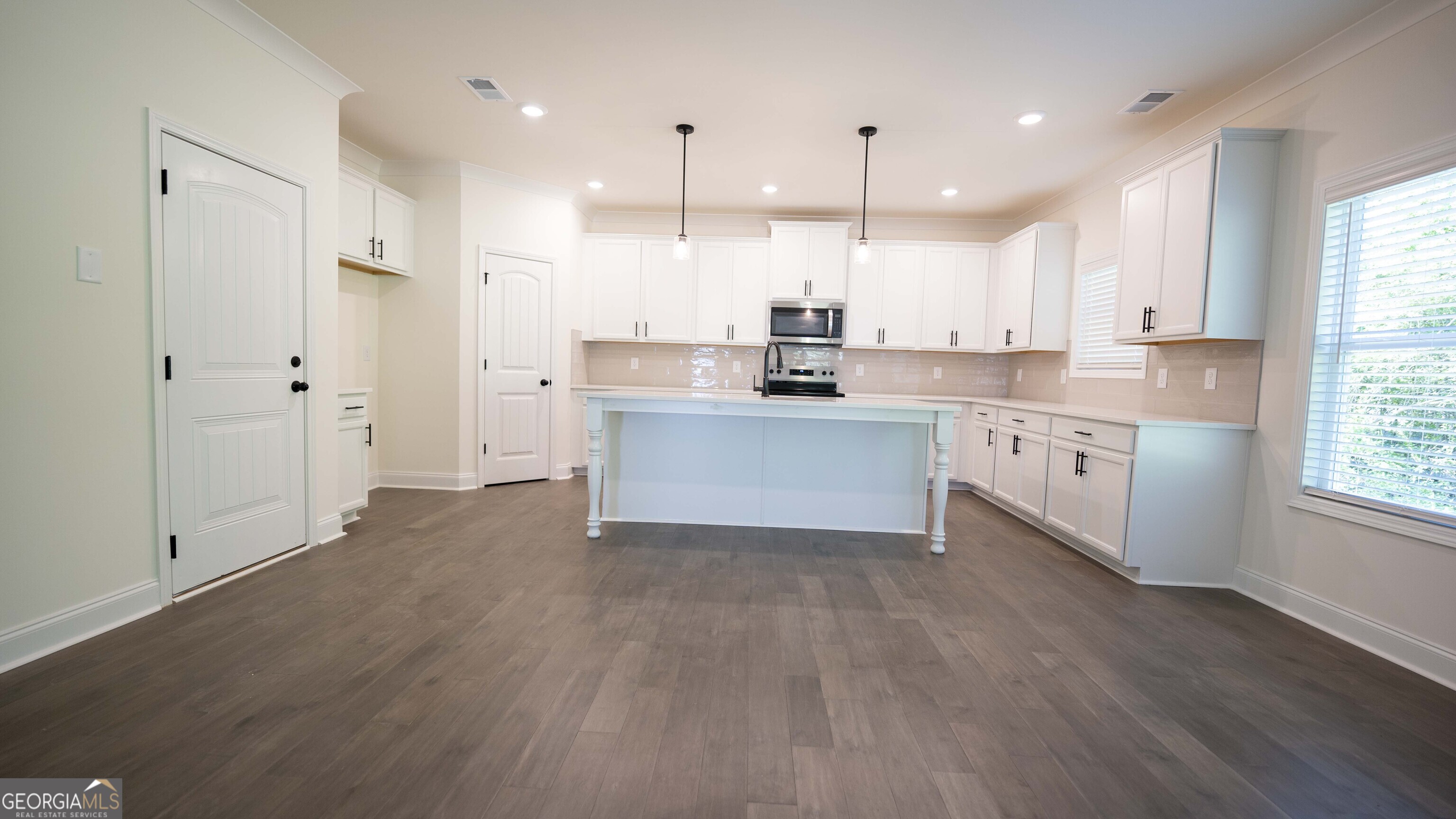 124 Bluecoat Trail Byron, GA 31008 - Photo 33 of 86 a large kitchen with cabinets wooden floor and stainless steel appliances