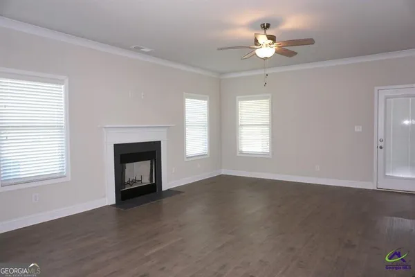 an empty room with windows and fireplace