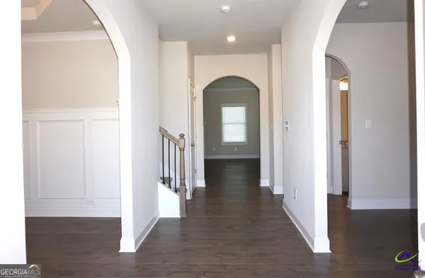 a view of a hallway with wooden floor and staircase