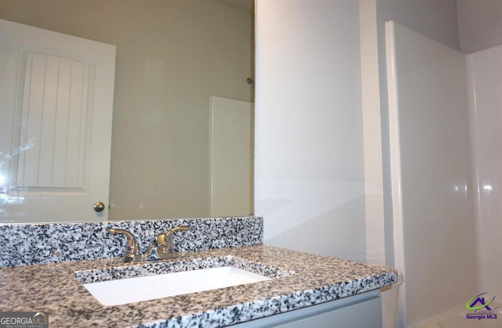 124 Bluecoat Trail Byron, GA 31008 - Photo 46 of 86 a bathroom with a granite countertop sink and a mirror
