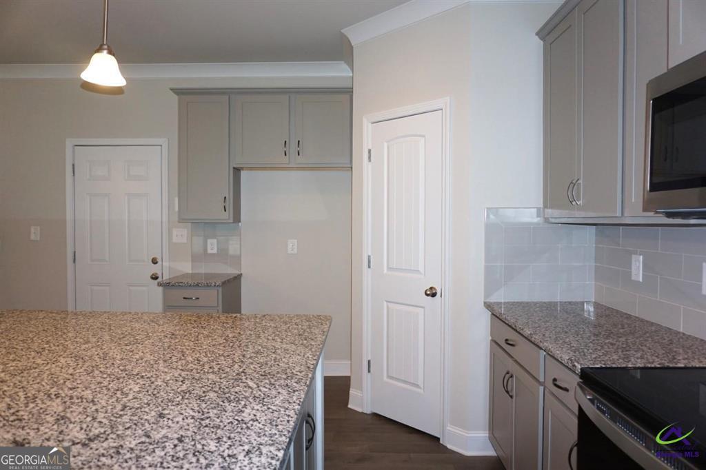 124 Bluecoat Trail Byron, GA 31008 - Photo 50 of 86 a kitchen with stainless steel appliances granite countertop a stove a sink and a refrigerator