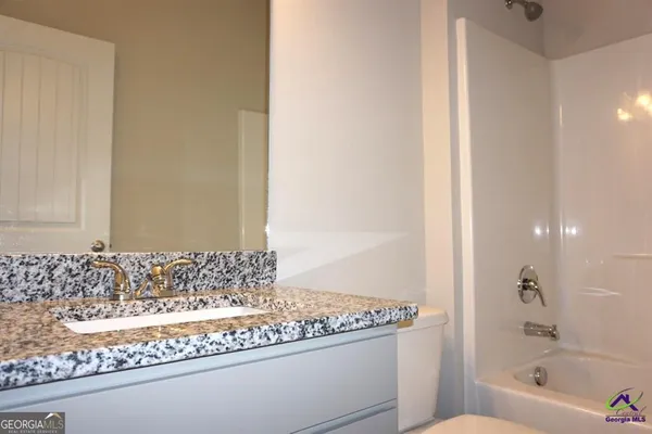 a bathroom with a granite countertop bathtub and a sink
