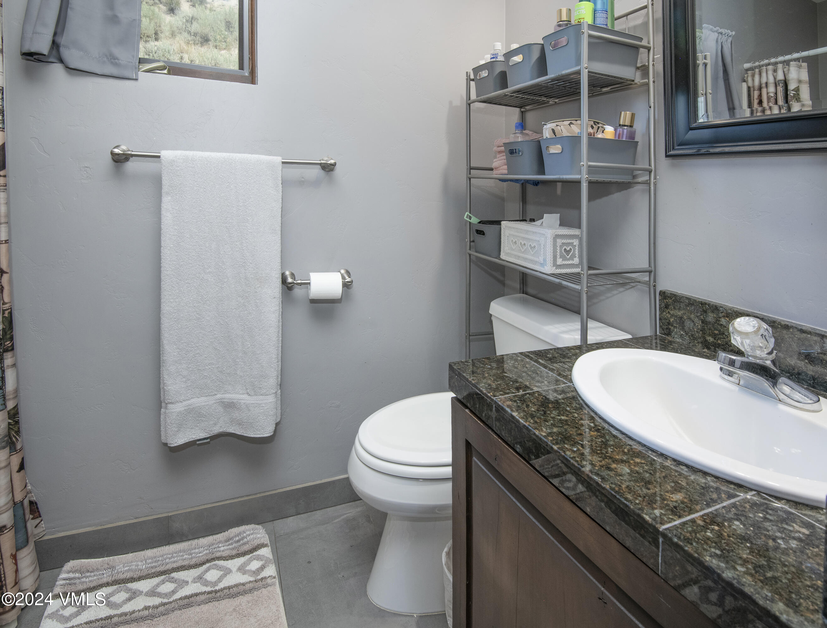 600 Nottingham Road, Unit 5 Avon, CO 81620 - Photo 12 of 13 a bathroom with a granite countertop sink a toilet and a mirror