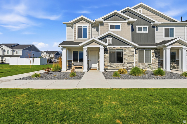 2216 South 1150 West Nibley, UT 84321 - Photo 2 of 34 Contemporary townhome exterior featuring multi-toned siding, stone accents, and a covered porch entry