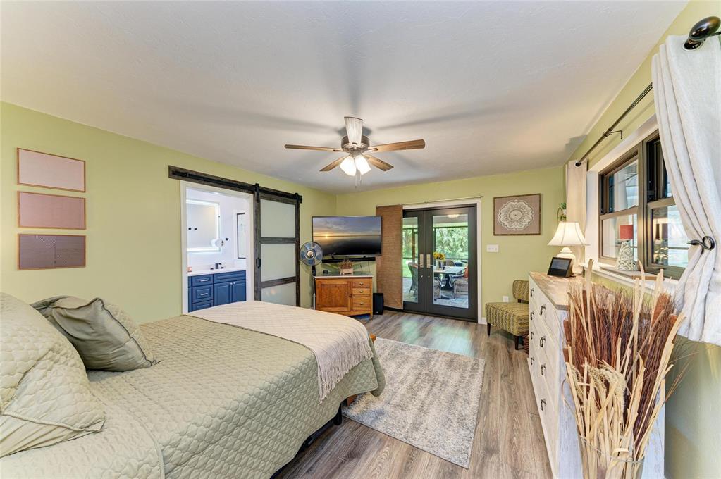 6114 Cypress Circle Bradenton, FL 34202 - Photo 15 of 67 a bedroom with a large bed a flat tv screen and a dresser