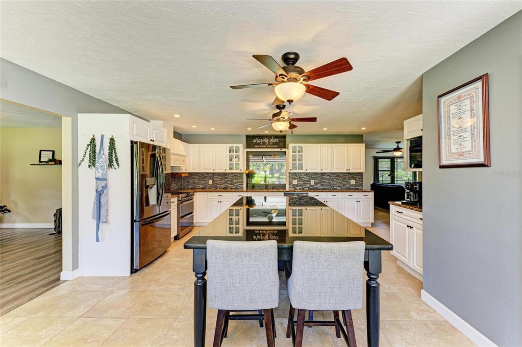 6114 Cypress Circle Bradenton, FL 34202 - Photo 5 of 67 a dining room with stainless steel appliances furniture a window and a kitchen view