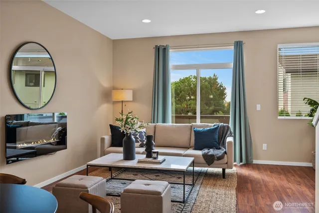 a living room with furniture a fireplace and a floor to ceiling window