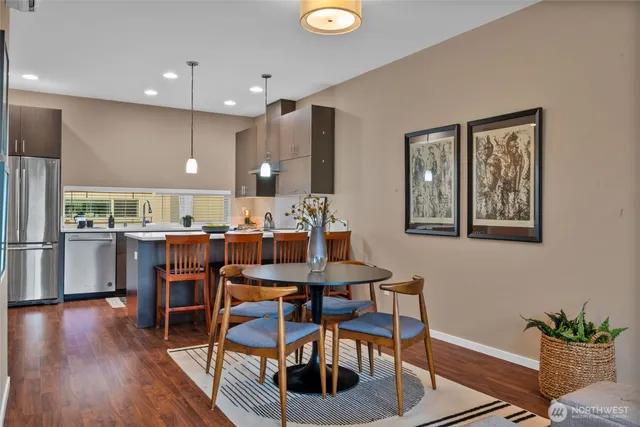 a kitchen with a dining table chairs and refrigerator