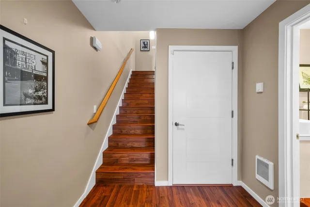 a view of a hallway with wooden floor and entryway