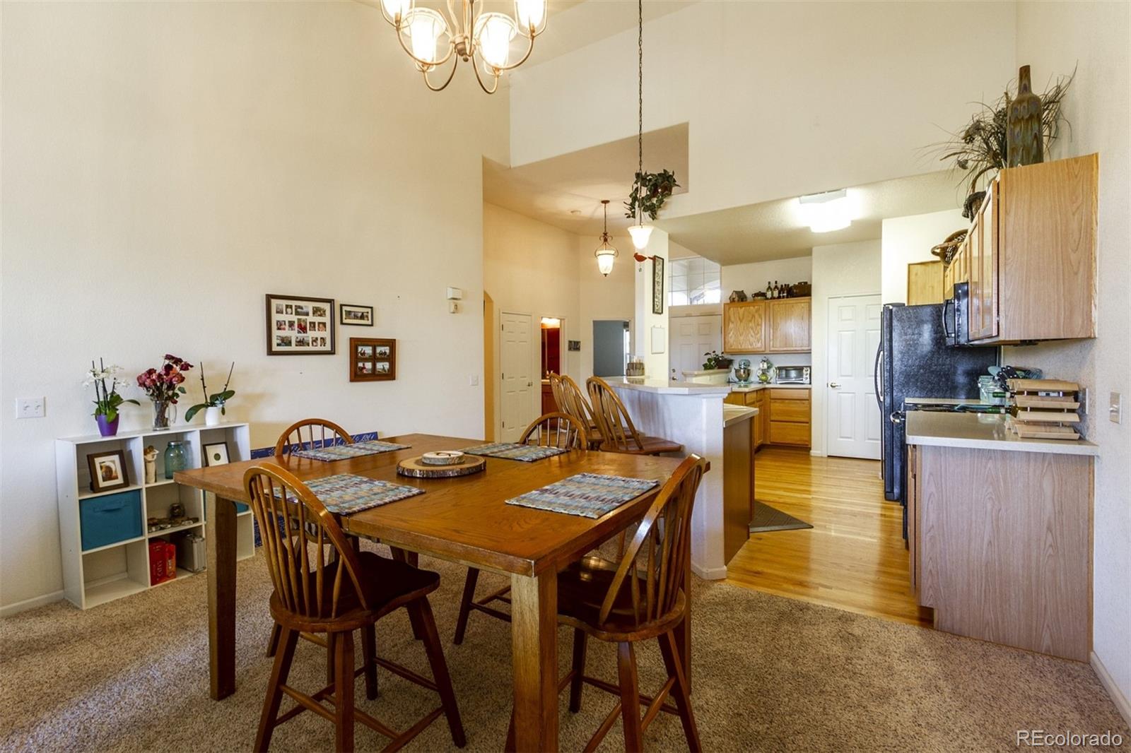 6697 South Reed Way, Unit B Littleton, CO 80123 - Photo 13 of 35 a view of a dining room with furniture and a chandelier