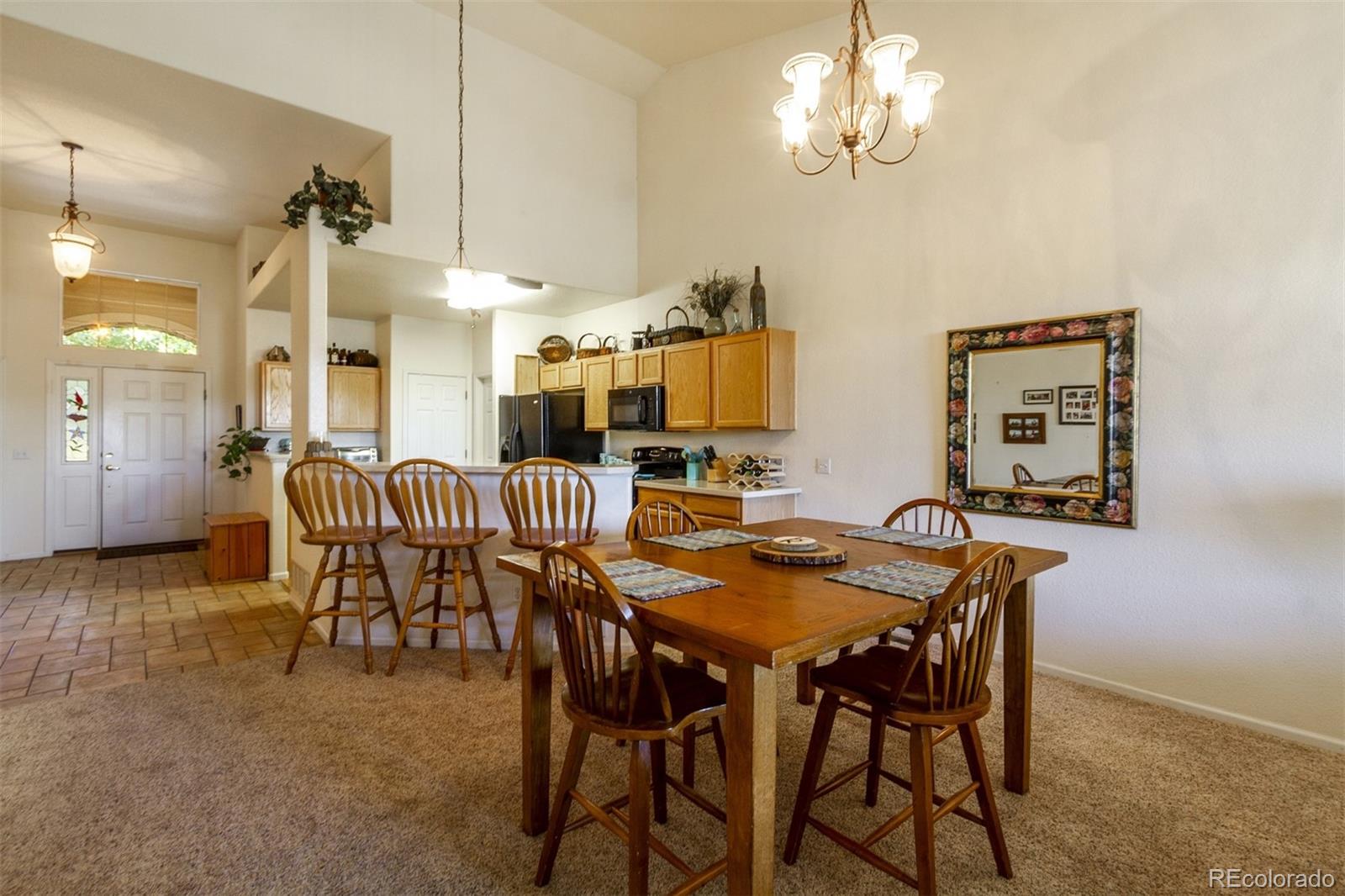 6697 South Reed Way, Unit B Littleton, CO 80123 - Photo 14 of 35 a dining room with furniture and chandelier