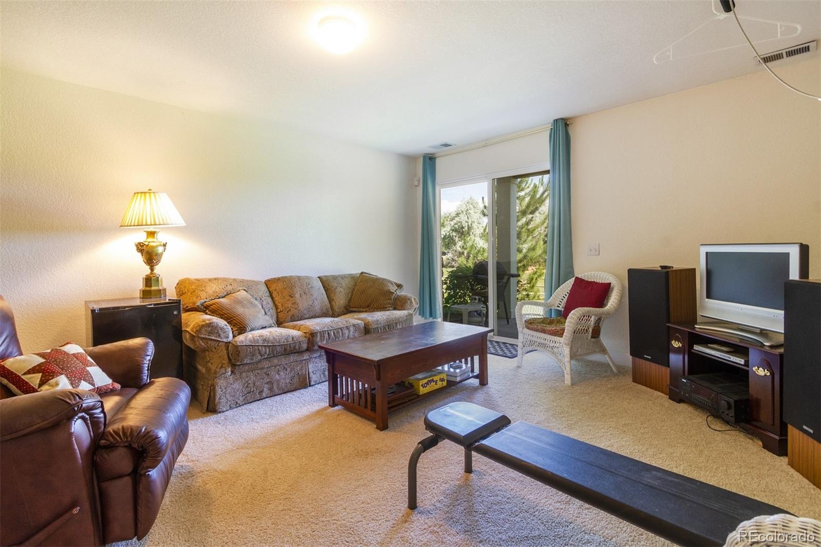 6697 South Reed Way, Unit B Littleton, CO 80123 - Photo 15 of 35 a living room with furniture a lamp a rug and a window
