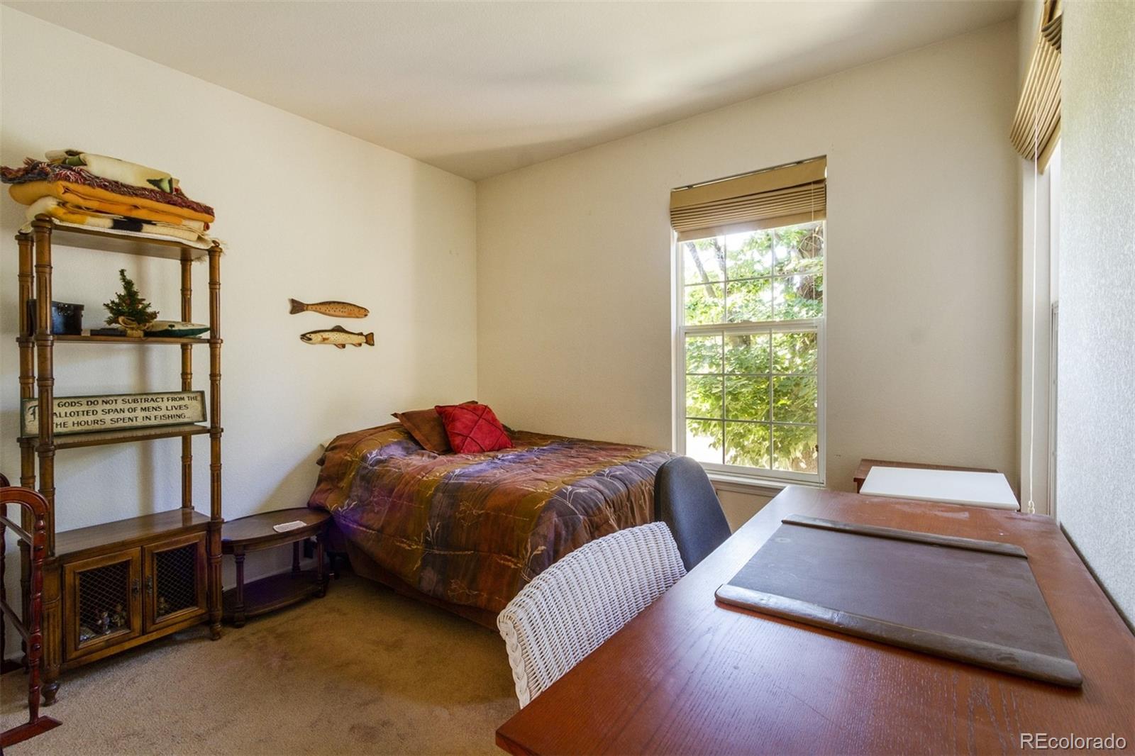 6697 South Reed Way, Unit B Littleton, CO 80123 - Photo 20 of 35 a bed sitting in a bedroom next to a window