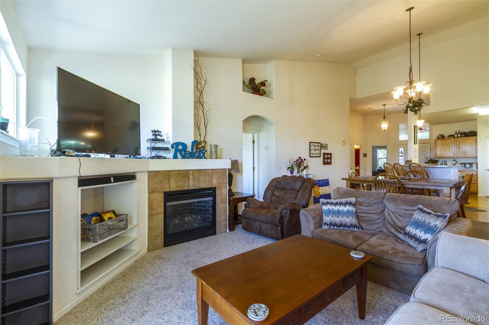 6697 South Reed Way, Unit B Littleton, CO 80123 - Photo 9 of 35 a living room with furniture a flat screen tv and a fireplace