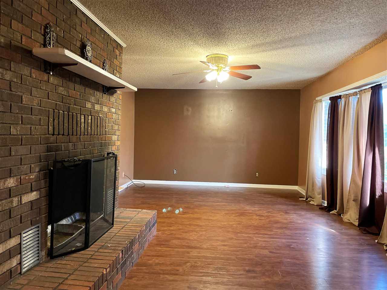 3990 Ebenezer Road Toone, TN 38381 - Photo 5 of 21 a view of an empty room with wooden floor and a fireplace