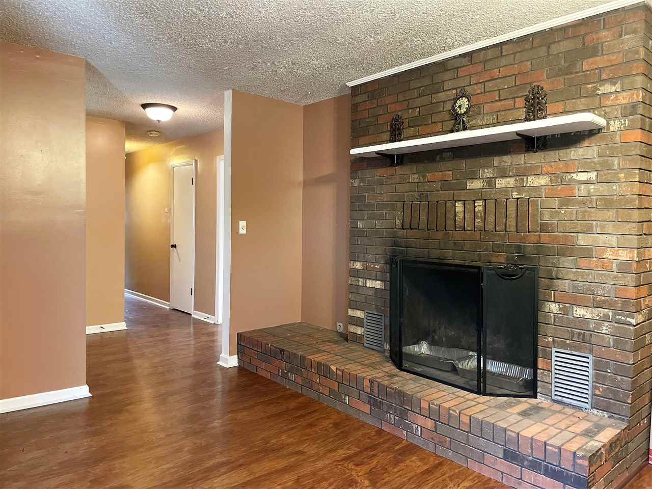 3990 Ebenezer Road Toone, TN 38381 - Photo 6 of 21 a view of an empty room with wooden floor and a fireplace