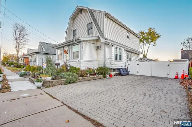 a view of a white house next to a road