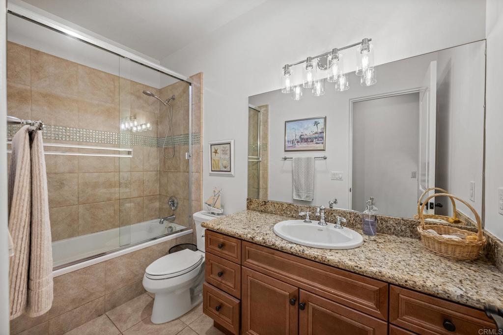 4149 Manchester Avenue Encinitas, CA 92024 - Photo 37 of 60 a bathroom with a granite countertop sink a toilet a mirror and shower