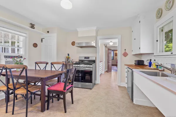 a kitchen with granite countertop a table chairs stove and cabinets