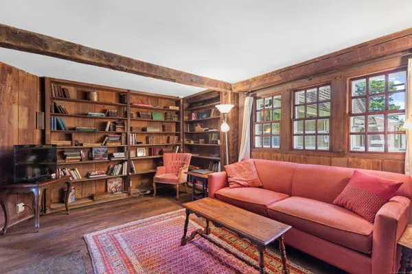 a living room with furniture a ceiling fan and a book shelf
