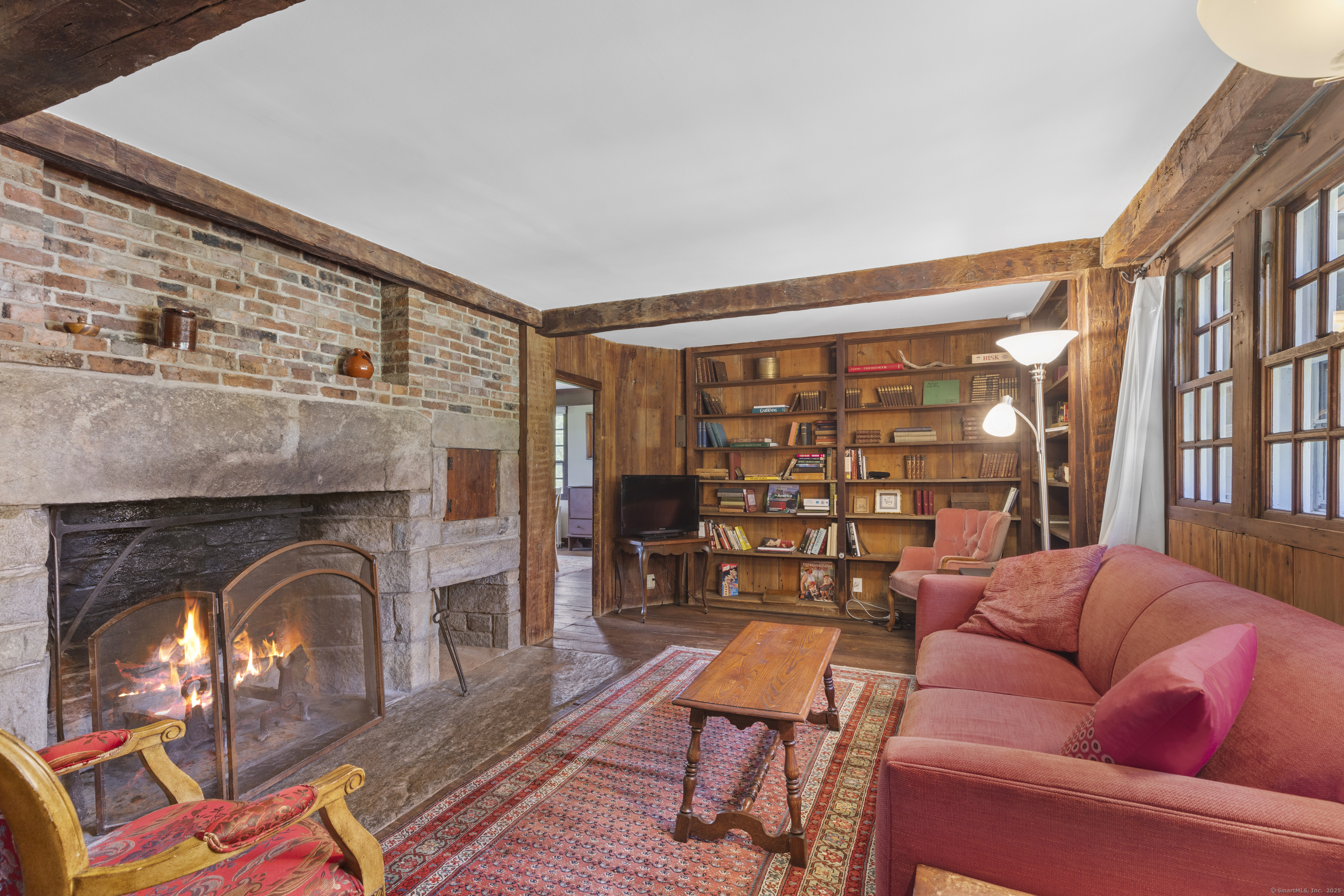 90 Duck Hole Road Guilford, CT 06437 - Photo 22 of 38 a living room with furniture a fireplace and a dining table with wooden floor