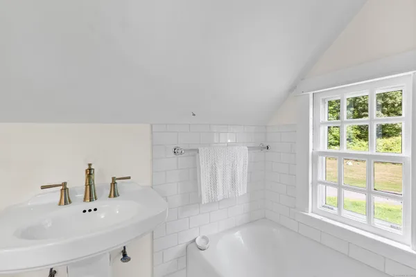 a bathroom with a bathtub a sink a vanity and a window