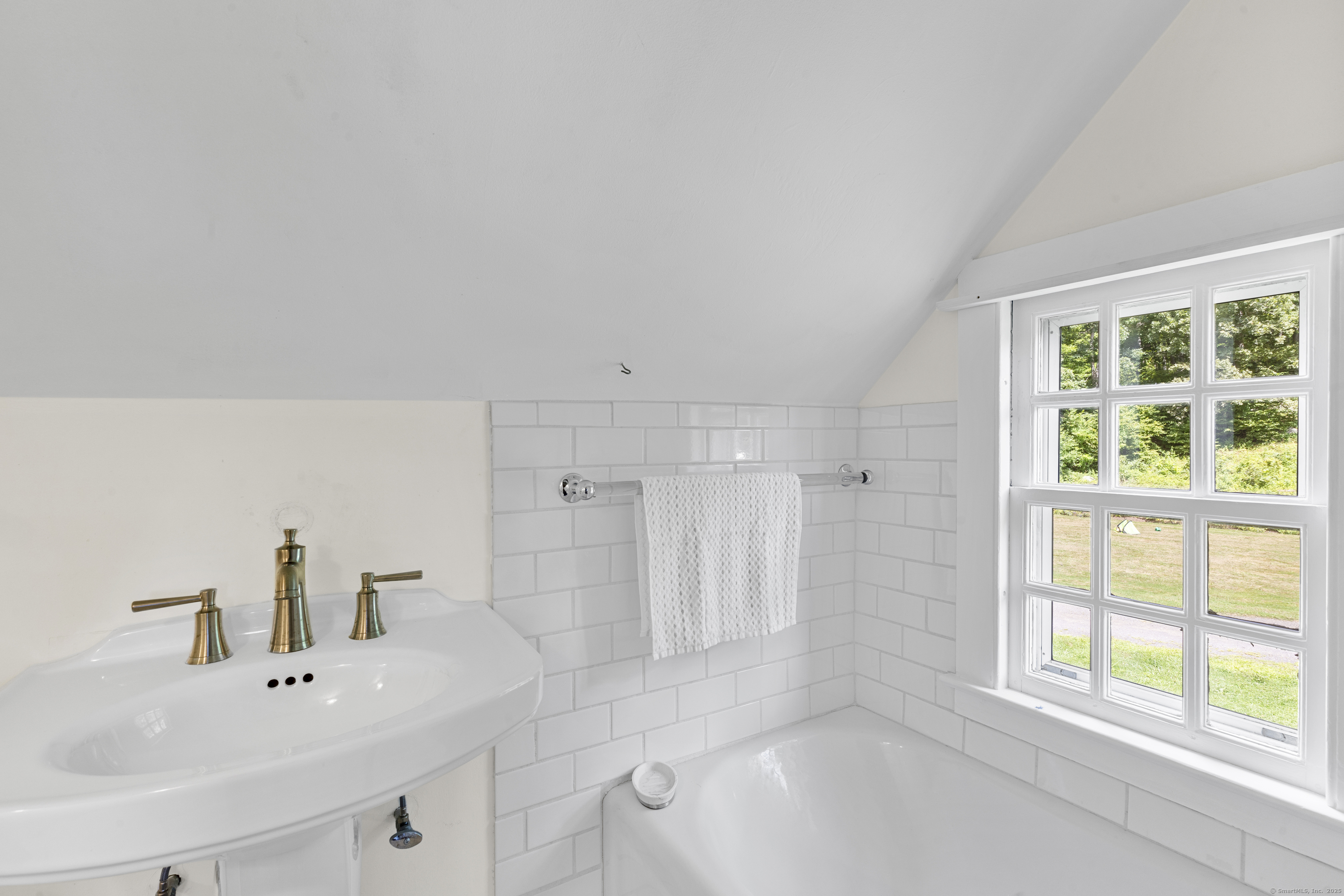 90 Duck Hole Road Guilford, CT 06437 - Photo 33 of 38 a bathroom with a bathtub a sink a vanity and a window
