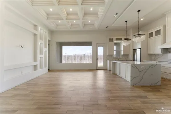 a view of an empty room and kitchen view