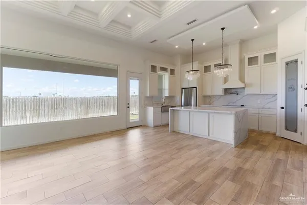 a large kitchen with stainless steel appliances kitchen island granite countertop a large cabinets a sink and a counter top space