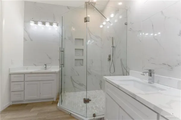 a bathroom with a sink shower and a mirror