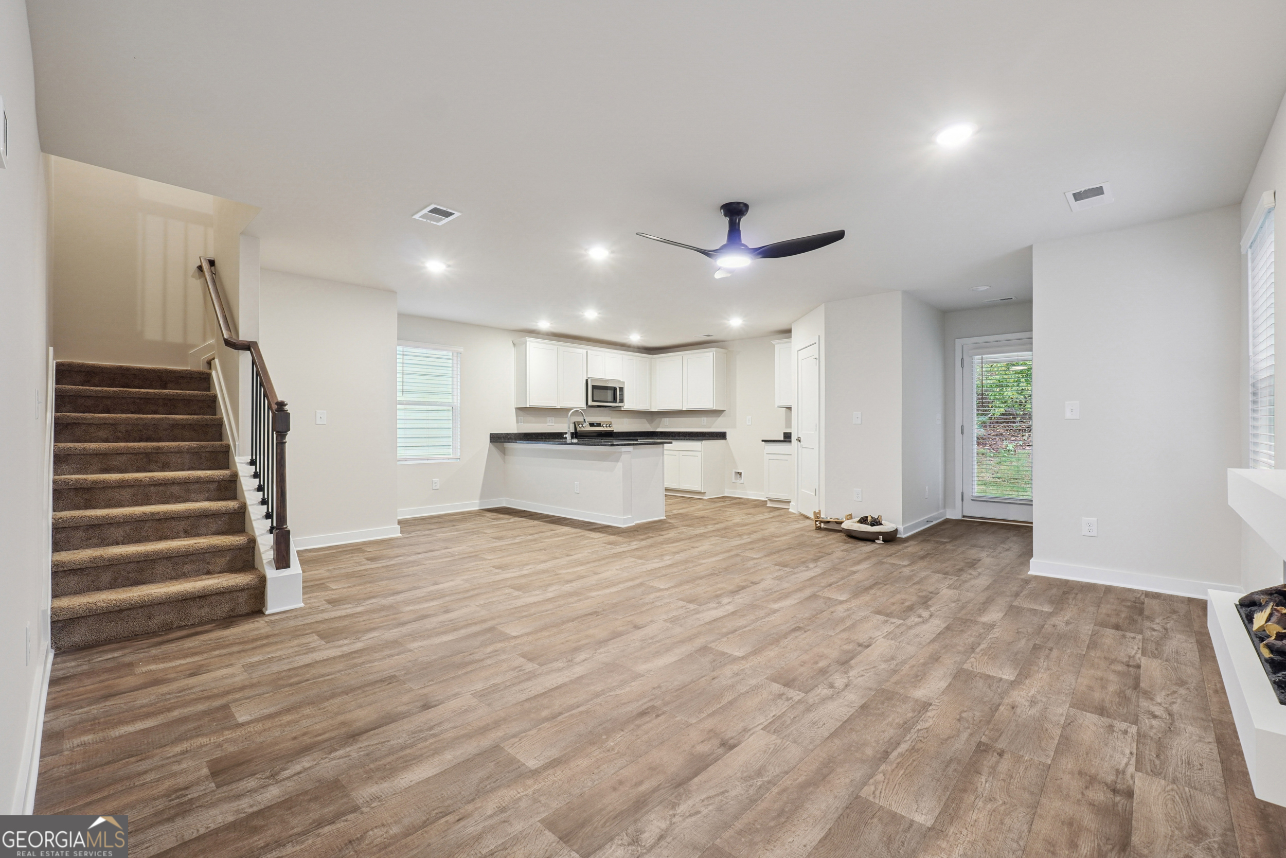 201 Harris Walk, Unit 20 West Point, GA 31833 - Photo 2 of 25 a view of an empty room with wooden floor and a kitchen