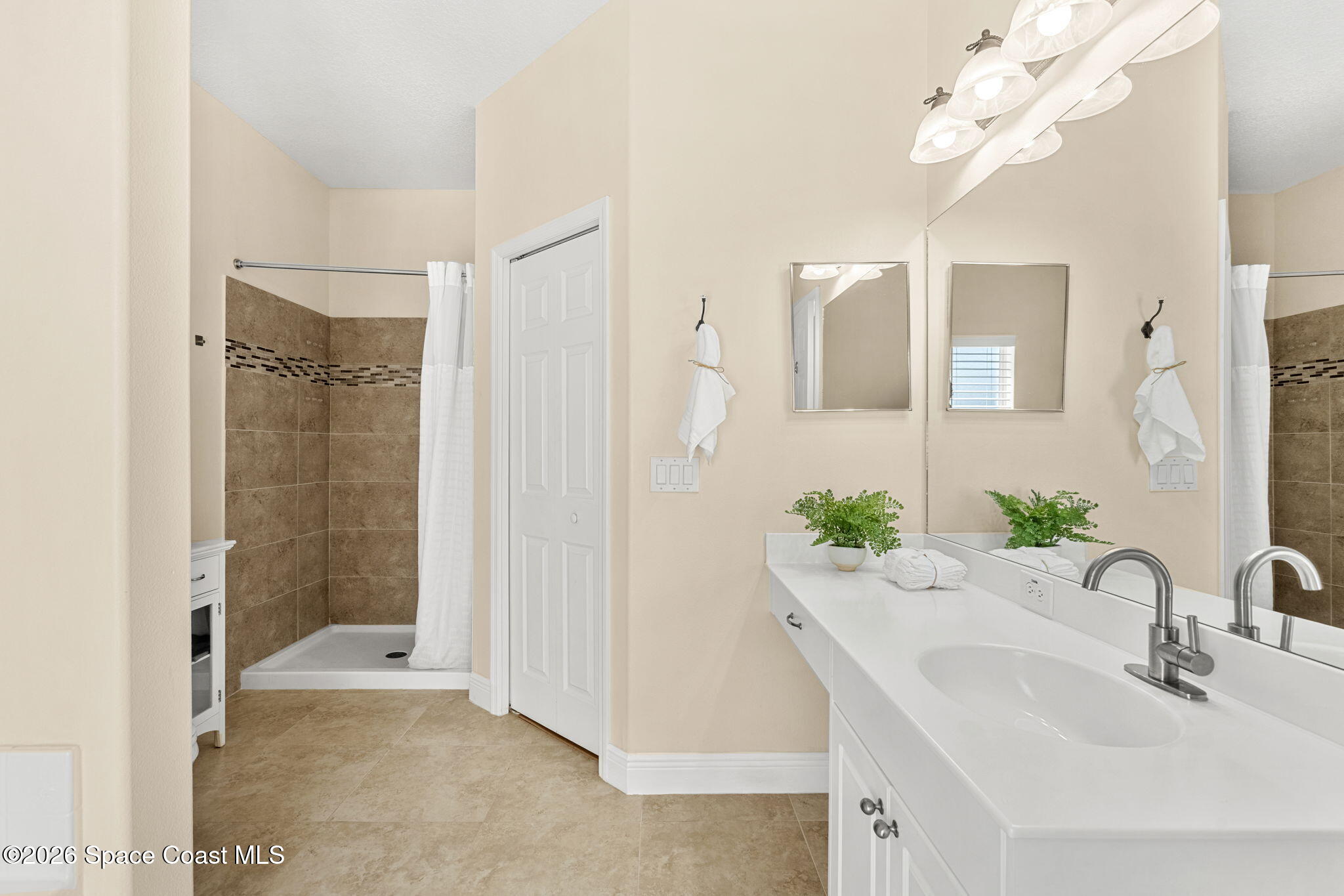 3751 Manitoba Way Rockledge, FL 32955 - Photo 32 of 64 a bathroom with a sink a mirror and a shower