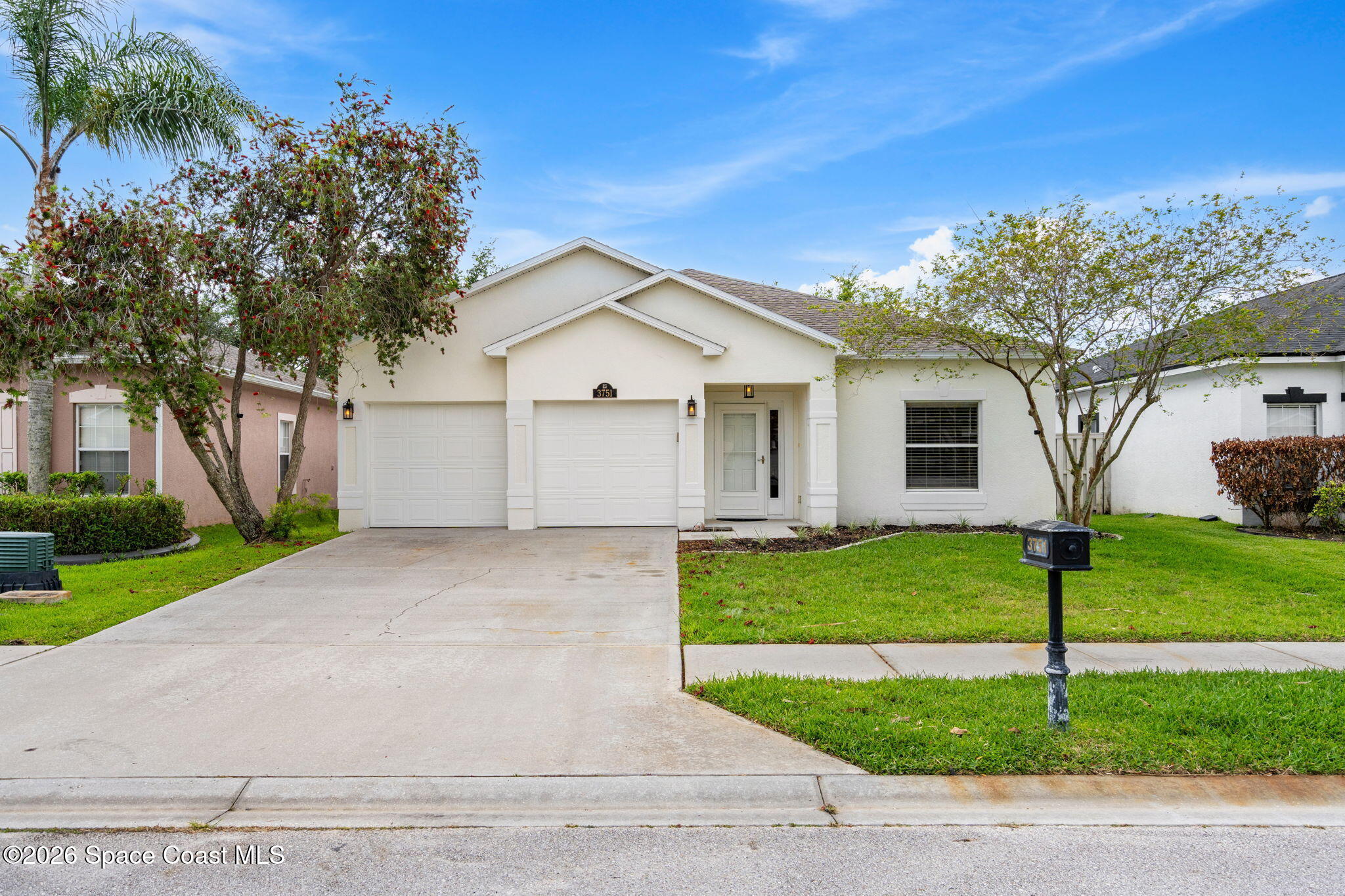 3751 Manitoba Way Rockledge, FL 32955 - Photo 63 of 64 a view of a white house next to a yard with big trees