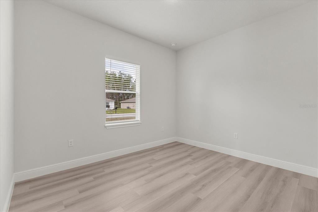 4016 Southwest 151st Street Ocala, FL 34473 - Photo 13 of 32 a view of an empty room with wooden floor and a window