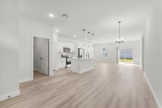 a view of a kitchen with refrigerator and wooden floor