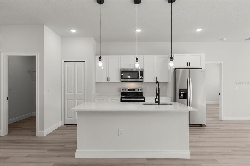 4016 Southwest 151st Street Ocala, FL 34473 - Photo 8 of 32 a kitchen with stainless steel appliances granite countertop a refrigerator a stove a sink and a wooden floors