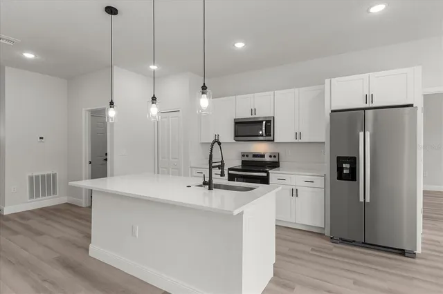a kitchen with stainless steel appliances a refrigerator sink and microwave
