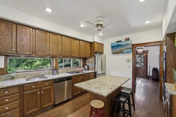 a kitchen with stainless steel appliances granite countertop a sink dishwasher and cabinets with wooden floor