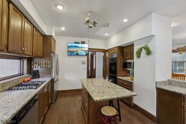 a kitchen with kitchen island a wooden floor and stainless steel appliances