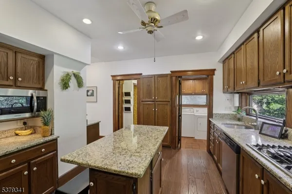 a kitchen with granite countertop cabinets stainless steel appliances and a counter space