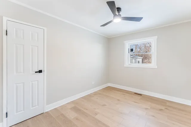 an empty room with a window and a ceiling fan