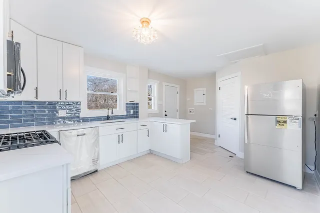 a kitchen with white cabinets and white appliances