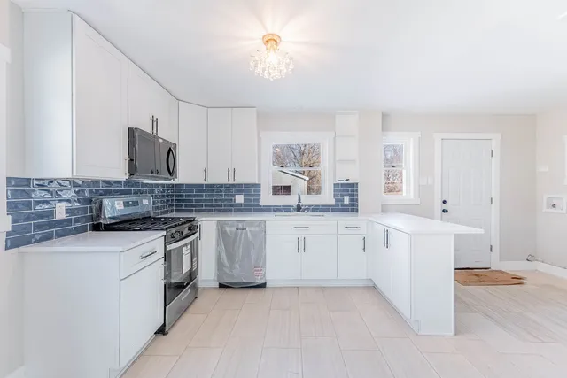 a large kitchen with cabinets and stainless steel appliances