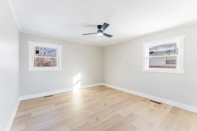a view of empty room with wooden floor