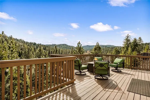 a balcony with wooden floor and outdoor seating