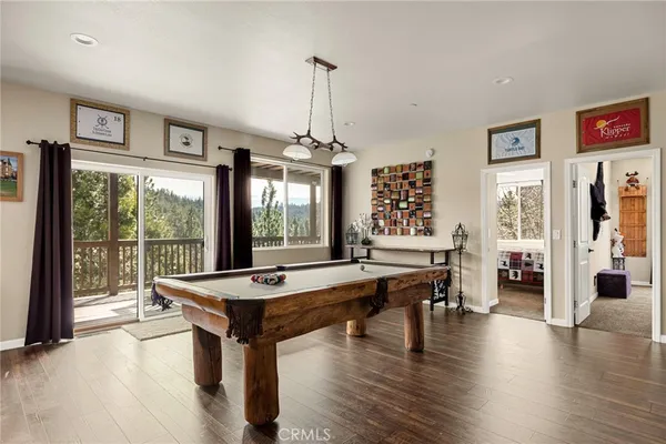 a living room with furniture pool table and a large window