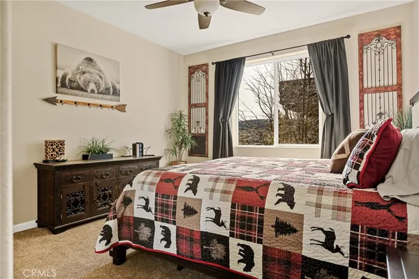 a bedroom with a bed a large window and book shelf